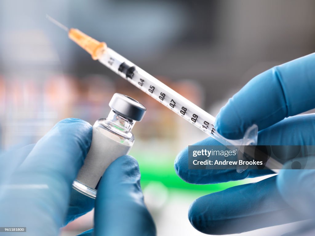 Doctor preparing to inject medication