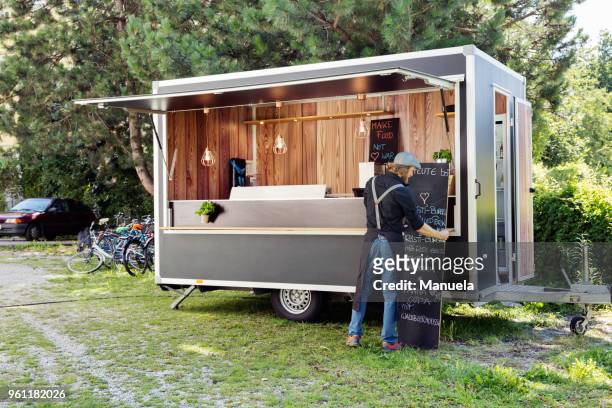 man opening food truck for business, innsbruck tirol, austria - foodtruck stockfoto's en -beelden