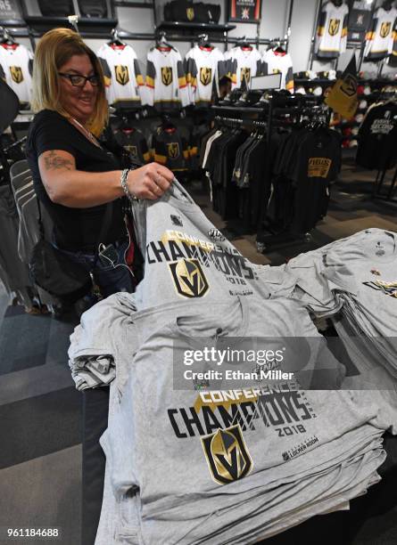 Vegas Golden Knights fan Suzanne Beecher of Nevada grabs a couple of "Western Conference Champions" T-shirts at the Arsenal retail store at City...
