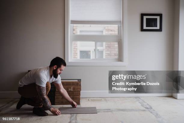 man installing floor tiles - flooring installation stock pictures, royalty-free photos & images