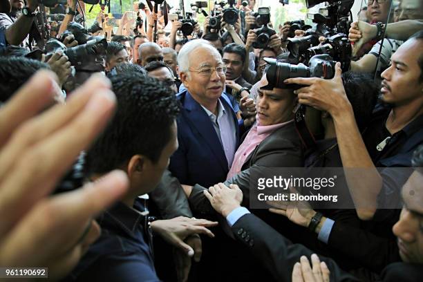 Najib Razak, Malaysia's former prime minister, center, is surrounded by members of the media as he arrives at the Malaysian Anti-Corruption...