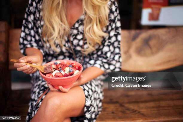 midsection of woman eating breakfast cereal at home - eating fiber stock pictures, royalty-free photos & images