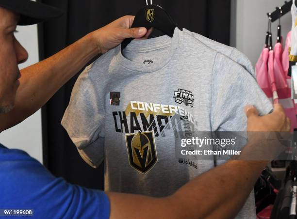 Patron looks at a Vegas Golden Knights "Western Conference Champions" T-shirt at the Arsenal retail store at City National Arena the day after the...