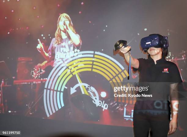 Woman enjoys a virtual reality music concert through a head-mounted display device in Tokyo, on May 14, 2018. ==Kyodo