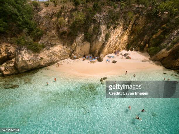 high angle view of people enjoying in sea against cliff - anguilla photos et images de collection