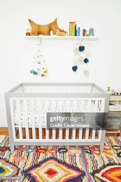 baby crib and toys in bedroom at home - crib stock pictures, royalty-free photos & images