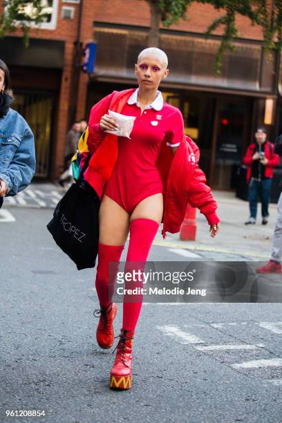 Model Jazzelle Zanaughtti wears a red bodysuit, red puffer jacket, thigh-high red stockings, and red platform boots during London Fashion Week...