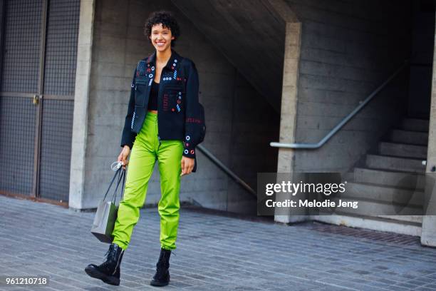 Model Dilone wears a black jacket with gromets, lime green pants, and black boots during London Fashion Week Spring/Summer 2018 on September 17, 2017...
