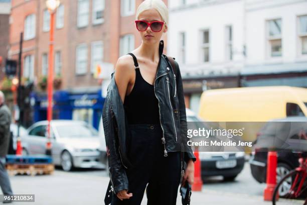 Model Marjan Jonkman wears red sunglasses and a black leather jacket, bodysuit, and jeans during London Fashion Week Spring/Summer 2018 on September...