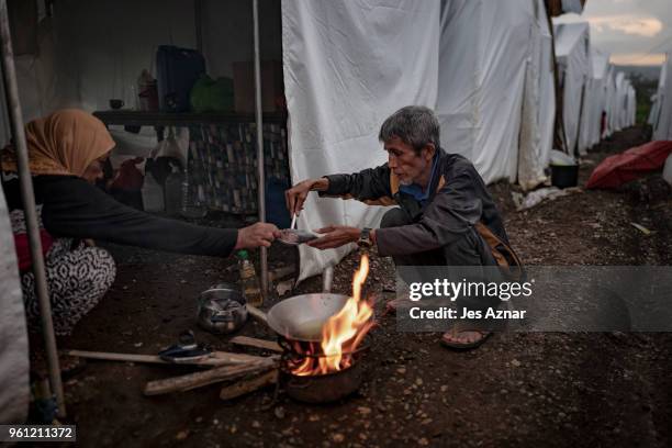 Omar Shariff and his wife Potre Soltan Macalatas cooks fish as they prepare their last meal before fasting for Ramadan inside the Sarimanok tent city...