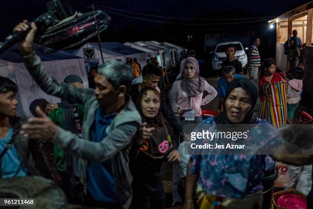 Displaced Marawi city residents gather their belongings from a truck as they arrive inside the Sarimanok tent city on May 16, 2018 in Marawi,...