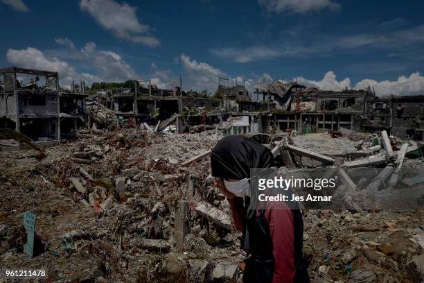 Woman standing amidst the destruction inside Marawi city on May 10, 2018 in Marawi, Philippines. With their homes destroyed and their properties...