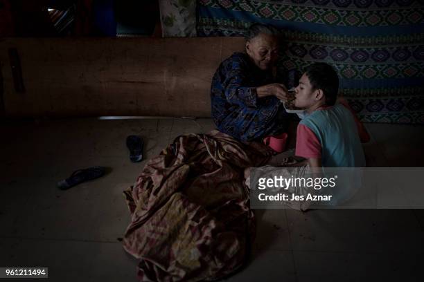 Elderly woman feed a child inside an evacuation center on May 11, 2018 in Marawi, Philippines. With their homes destroyed and their properties looted...