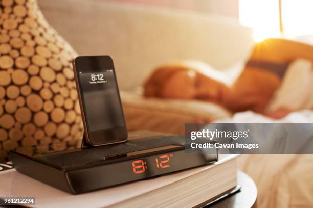 smart phone on modern alarm clock in bedroom - woman sleeping table stock pictures, royalty-free photos & images