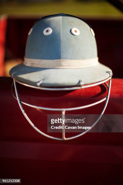 close-up of sports helmet on retaining wall in sunny day - red polo stock pictures, royalty-free photos & images