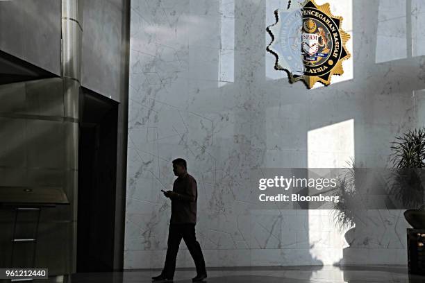 Man walks past the logo of the Malaysian Anti-Corruption Commission at the agency's headquarters ahead of the arrival of former Malaysian Prime...