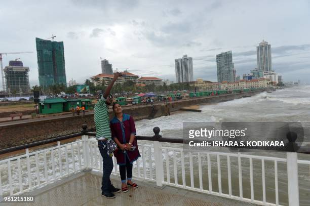 Sri Lankan couple take a selfie photograph by the sea at Galle Face Beach in the heart of the Sri Lankan capital Colombo on May 22, 2018.