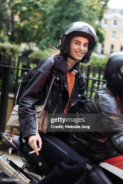 Model Estella Brons wears a black leather jacket, Dior handbag, and rides a motorocycle during London Fashion Week Spring/Summer 2018 on September...