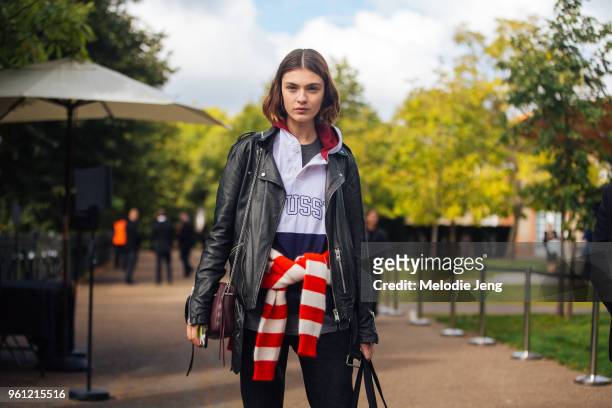 Model Milena Litvinovskaya wears a black leather jacket, Stussy sweatshirt, and red striped Diane Von Furstenberg sweater around her waist during...