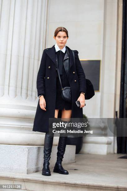 Model Michelle van Bijnen wears a preppy black peacoat, black top, black Gucci bag, black thigh-high boots during London Fashion Week Spring/Summer...