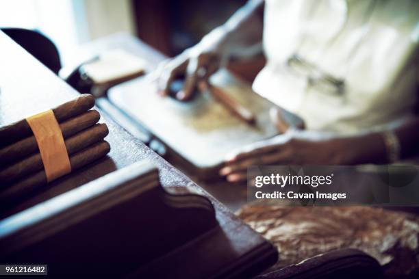 woman manufacturing cigar in factory - kompetenz bündeln stock-fotos und bilder