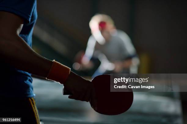 close-up of man holding table tennis racket - friends table tennis stock pictures, royalty-free photos & images