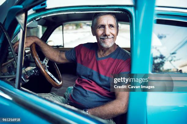 man looking away while sitting in vintage car - collector's car stock-fotos und bilder