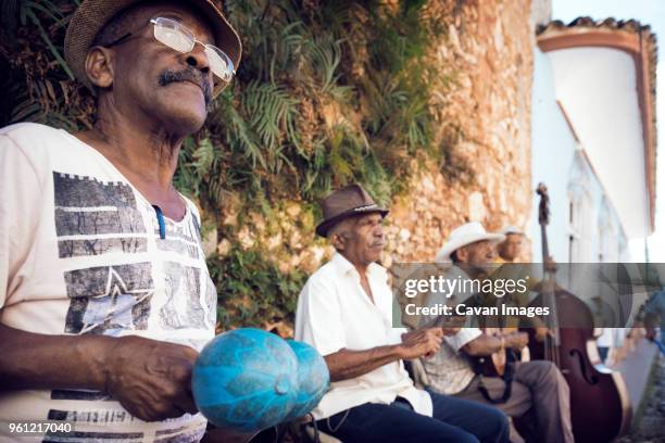 street musicians playing musical instruments - plucking an instrument - fotografias e filmes do acervo