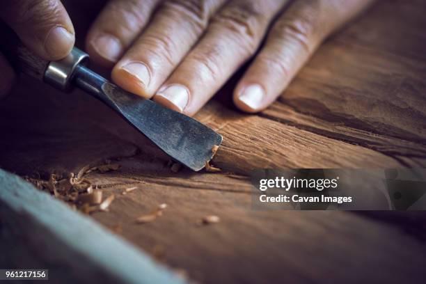 cropped image of man carving in workshop - kunstnijverheid stockfoto's en -beelden