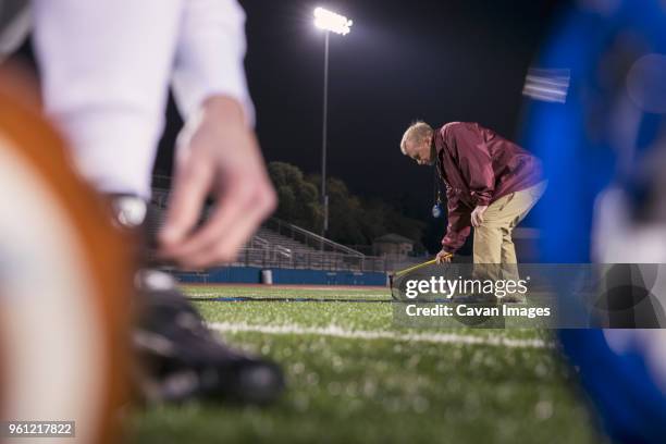 american football coach placing agility ladder on turf at stadium - bent ladder stock pictures, royalty-free photos & images