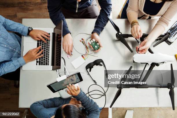 overhead view of students working on electrical equipment at table in classroom - virtual reality classroom stock pictures, royalty-free photos & images