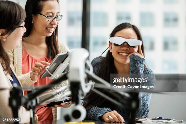 female student wearing virtual reality glasses while teacher using tablet computer in classroom - philippines friends stock pictures, royalty-free photos & images