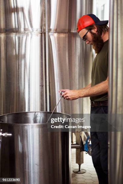 brewer using thermometer while working at brewery - beer goggles stock pictures, royalty-free photos & images