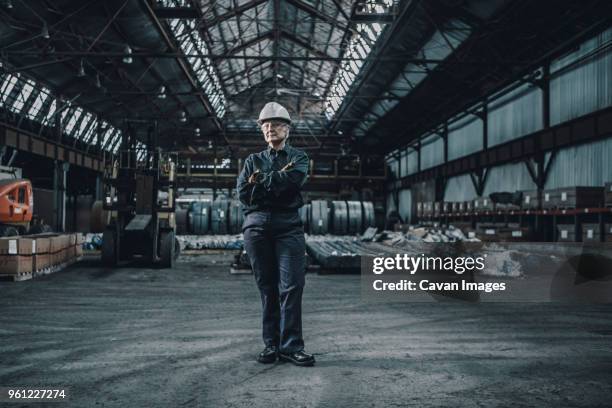 portrait of confident female worker with arms crossed standing in metal industry - manufacturing occupation stock pictures, royalty-free photos & images