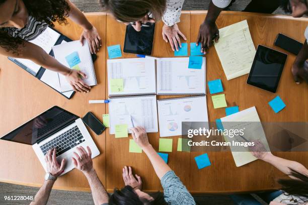 high angle view of business people planning in board room - multi ethnic business people having discussion at table in board room stockfoto's en -beelden