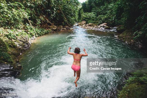 high angle view of carefree woman jumping into lake amidst forest - kansas city missouri stockfoto's en -beelden