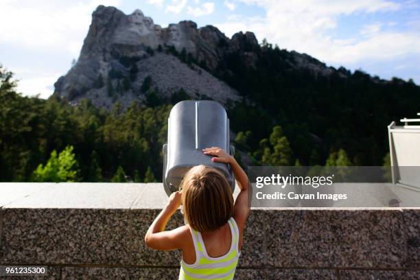 rear view of girl looking through telescope at mount rushmore national memorial - viewfinder foto e immagini stock