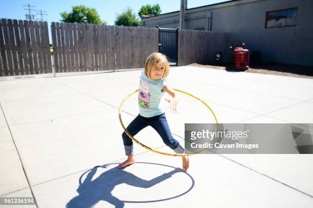 portrait of girl playing with hula hoop at playground during summer - hula hoop ストックフォトと画像