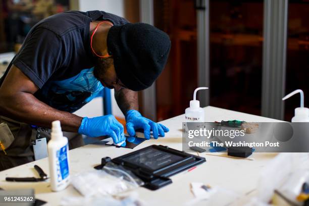 Formlabs employee cleans a mirror taken from inside a 3D printer at a workspace at the Formlabs office in Somerville, MA on May 8, 2018.