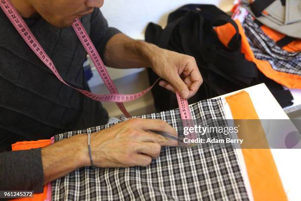 Afghan refugee Amir Mohammadi sews life preserver material and fabric together to make a bag at the Lesvos Solidarity organization's Safe Passage...