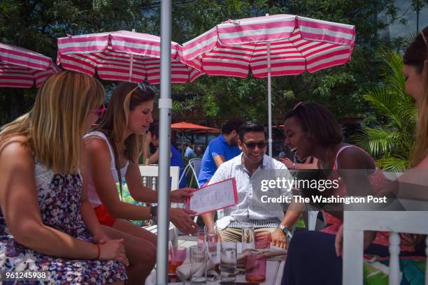 Bartender Jorge Diaz Perez, C, shares a laugh with Kristin Huners, 2nd from R, as Huners spends time with friends, Rachel Toppings, L, Julia Smith,...