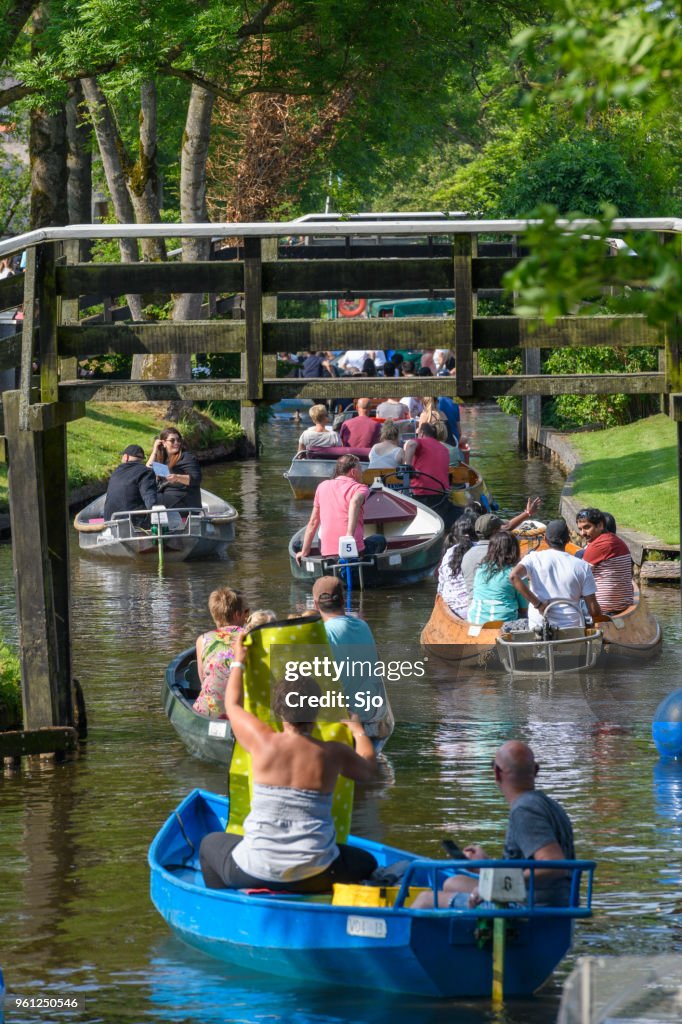 Tourists enjoying a boat tour on the canals of Giethoorn in The Netherlands