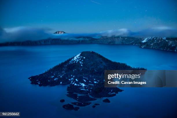 high angle view of wizard island amidst crater lake against sky during dawn - wizard island stock pictures, royalty-free photos & images