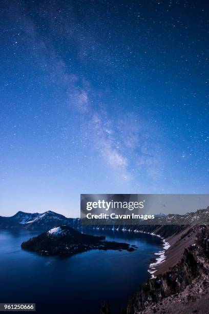 majestic view of crater lake against milky way during dawn - wizard island stock pictures, royalty-free photos & images