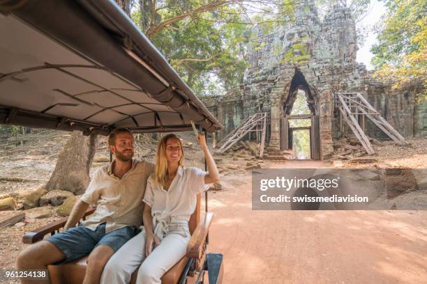touristen genießen schlepper schlepper fahren bei einem besuch in den antiken tempeln - siemreap tempelkomplex stock-fotos und bilder