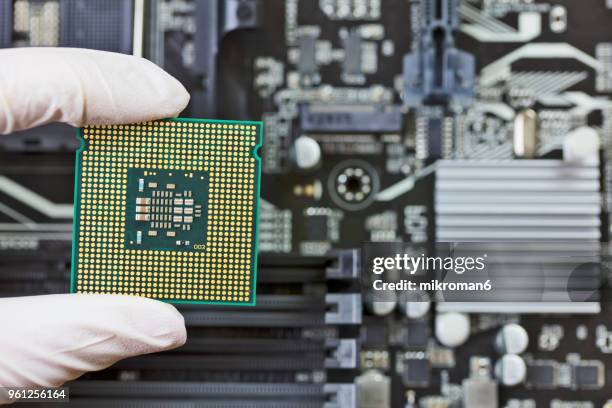human hand to installing integrated circuit, cpu - mikroman6 imagens e fotografias de stock