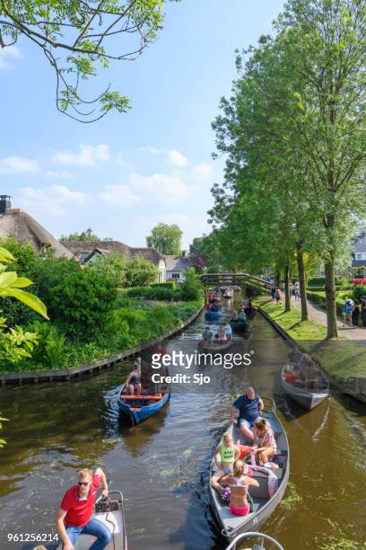 toeristen die genieten van een rondvaart op de grachten van giethoorn in nederland - motorboot varen stockfoto's en -beelden