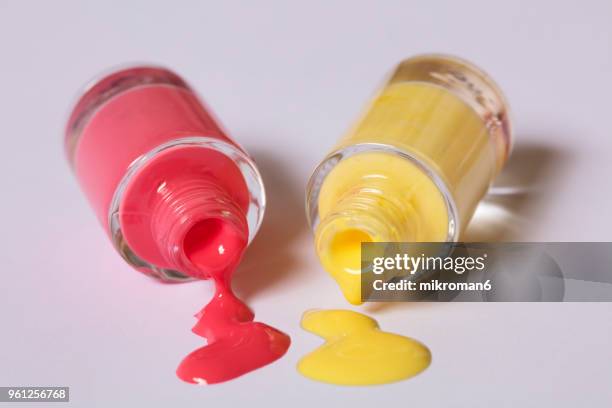 pink and yellow nail varnish spilling onto white background. - mikroman6 imagens e fotografias de stock