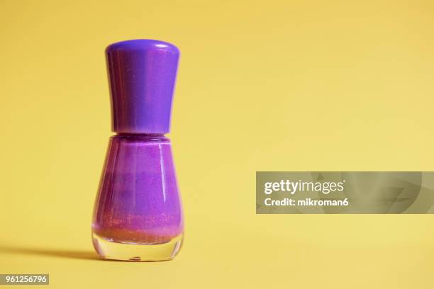 purple nail polish bottle on yellow background. - mikroman6 imagens e fotografias de stock