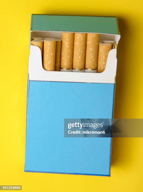 cigarette box on yellow background - mikroman6 imagens e fotografias de stock